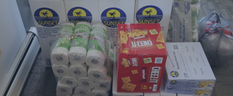 Shaded background image, stack of paper products and boxed food