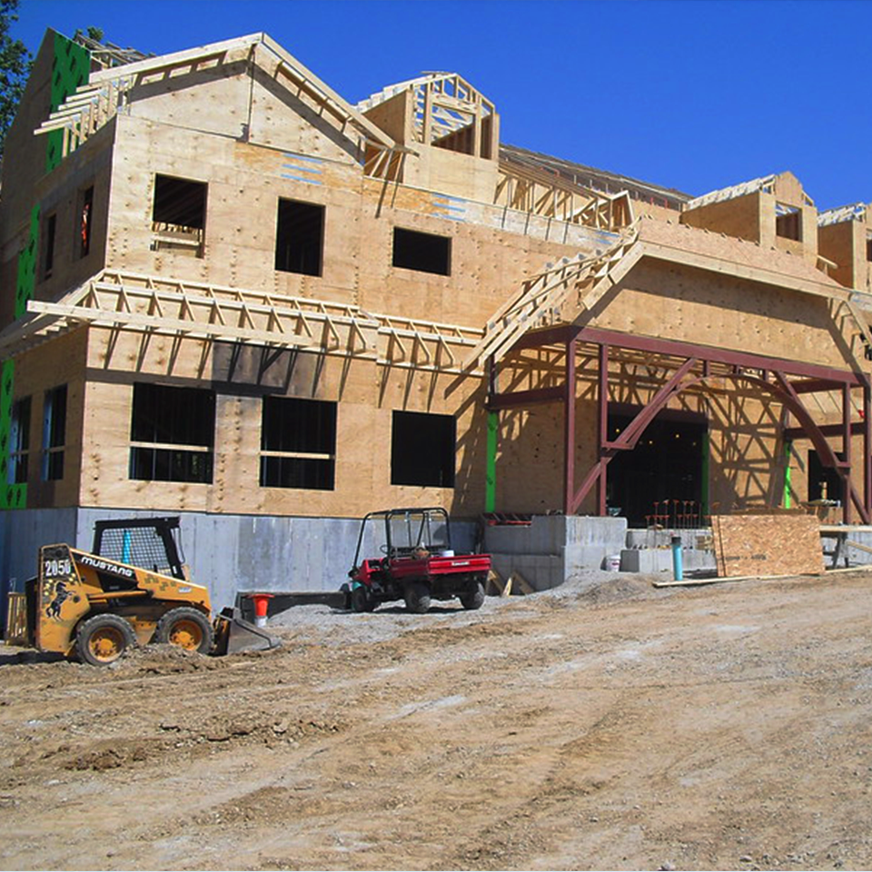 A new Ronald McDonald House program under construction, bare foundation, uncovered plywood walls and frame