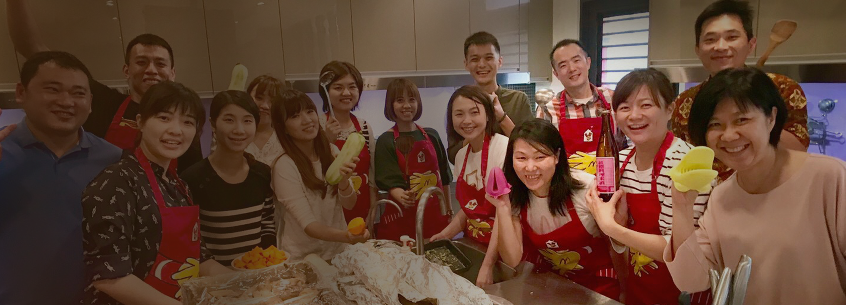 Volunteers posing around food prepared at and for their local Ronald McDonald House program