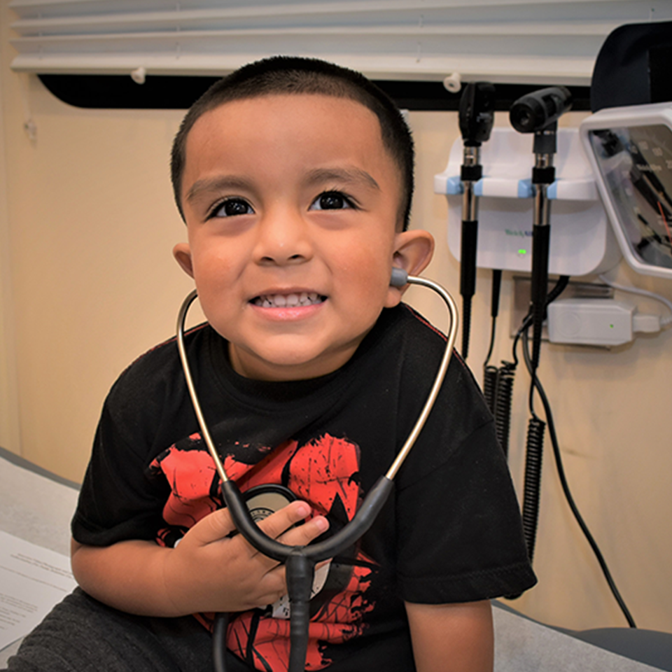 Child with stethoscope sitting on table in a care mobile