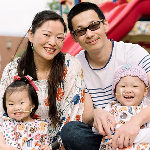 RMHC parents smile with their two children giggling